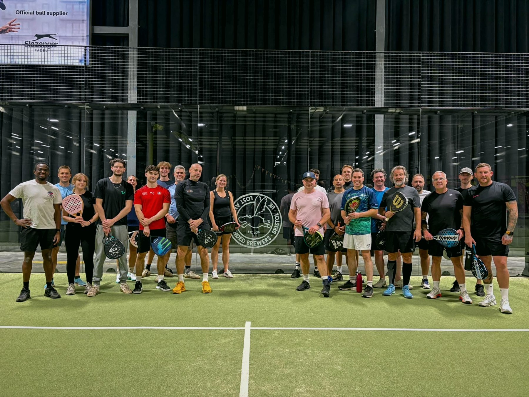 The Friday group lined up on court with their rackets after a session at Rocket Padel Bristol